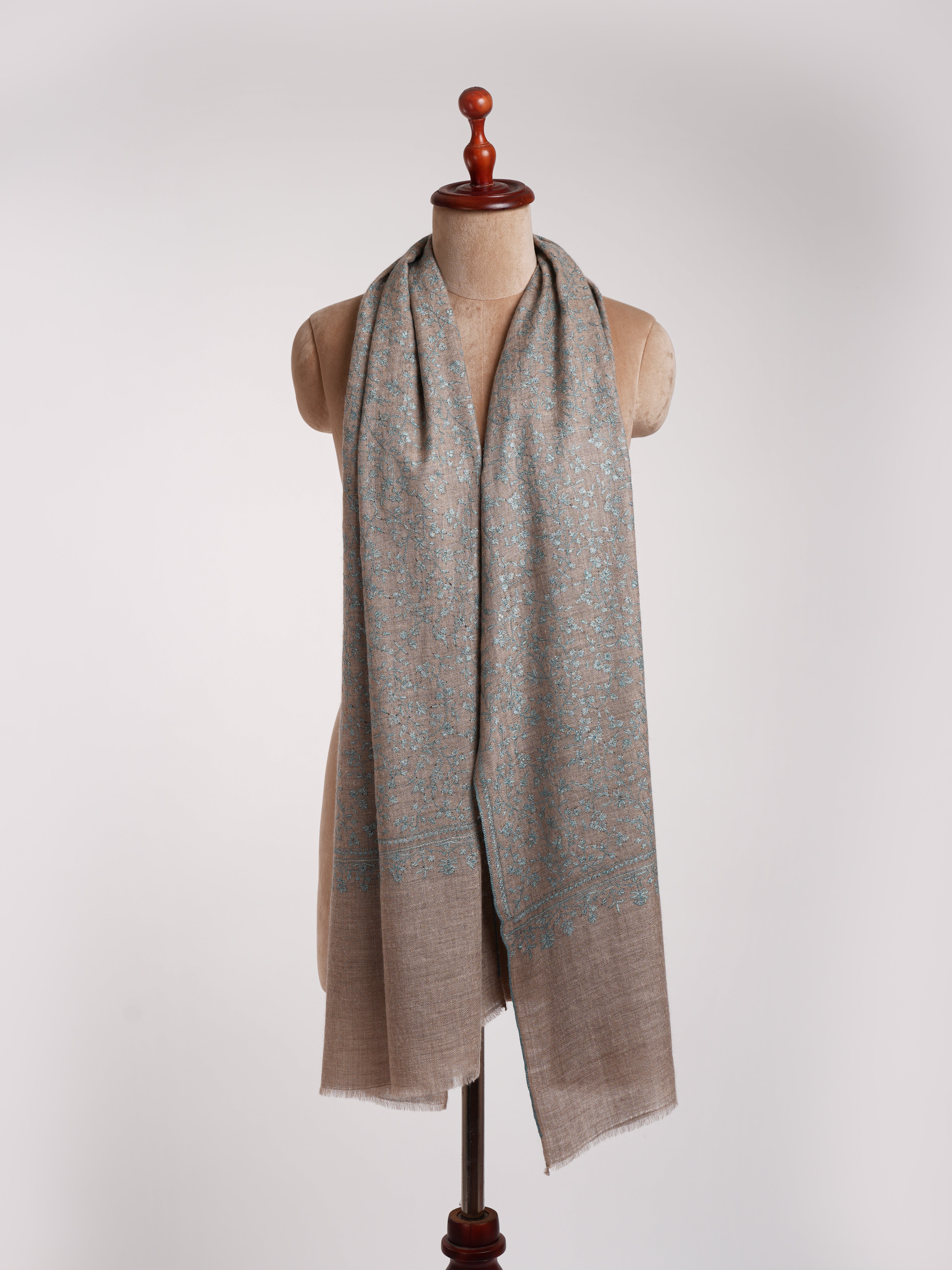 Stola ricamata in cashmere grigio naturale con ricamo blu.