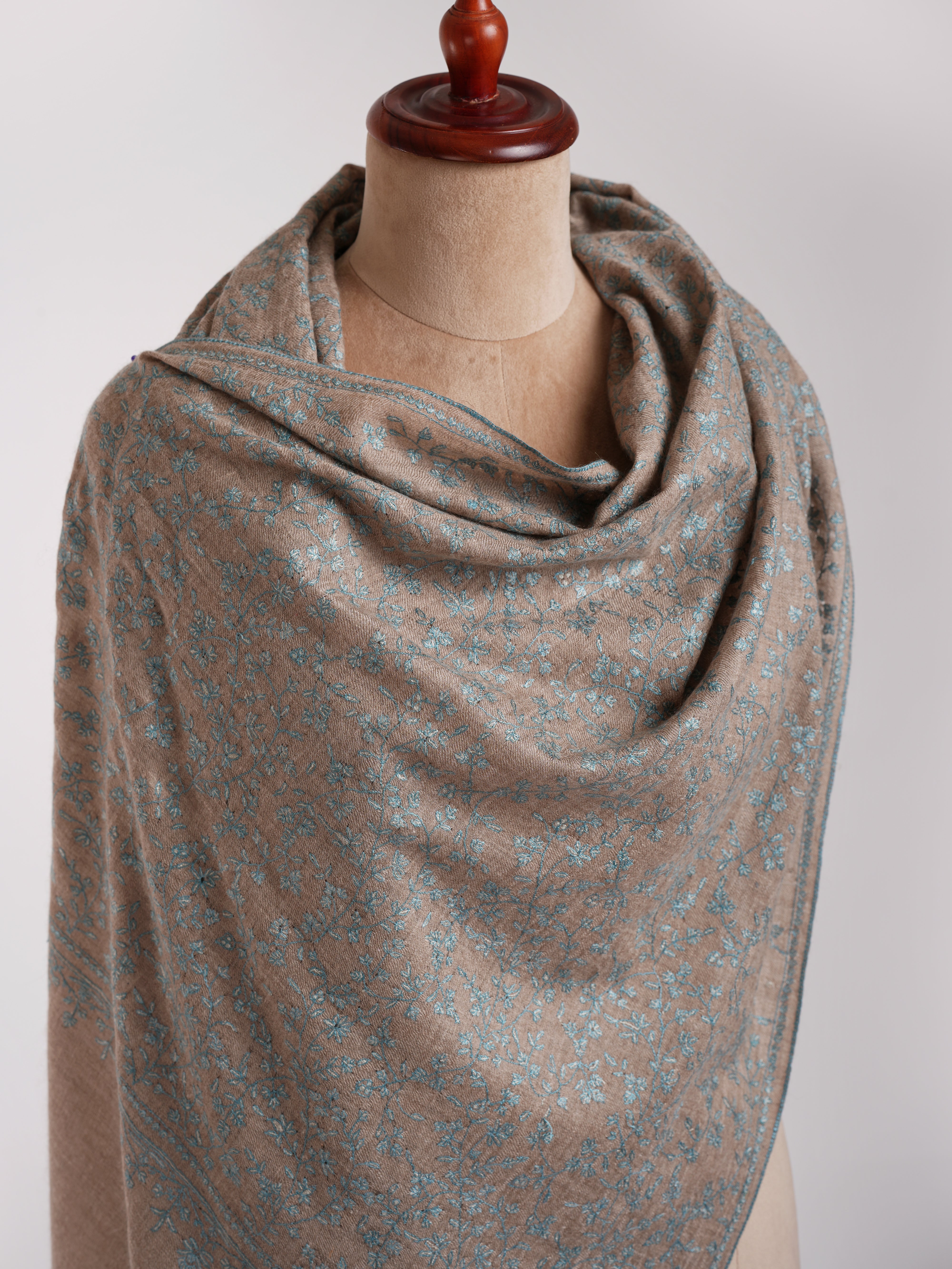 Stola ricamata in cashmere grigio naturale con ricamo blu.